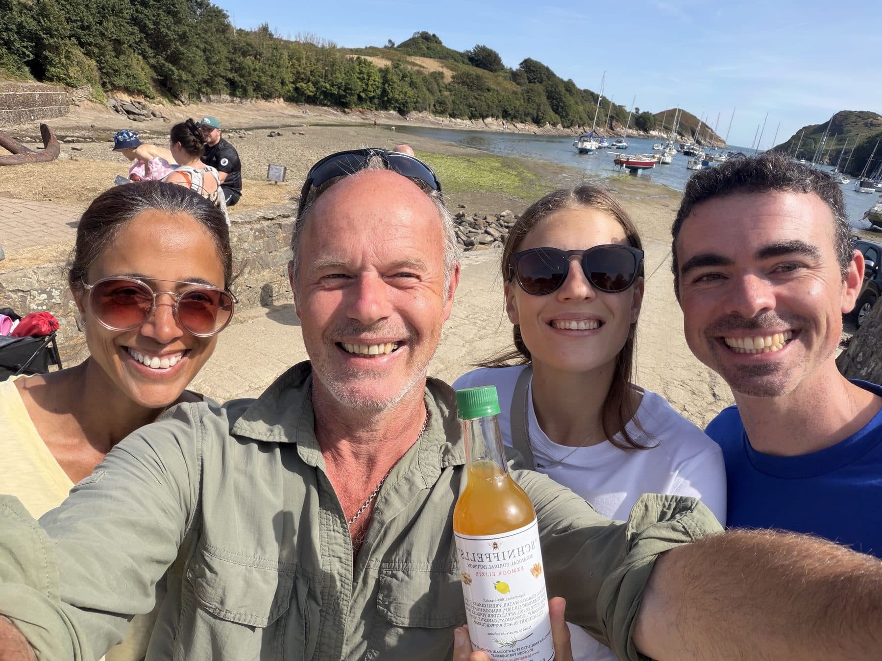 Pete and friends at Watermouth Harbour, holding a bottle of Schniffells in the sunshine