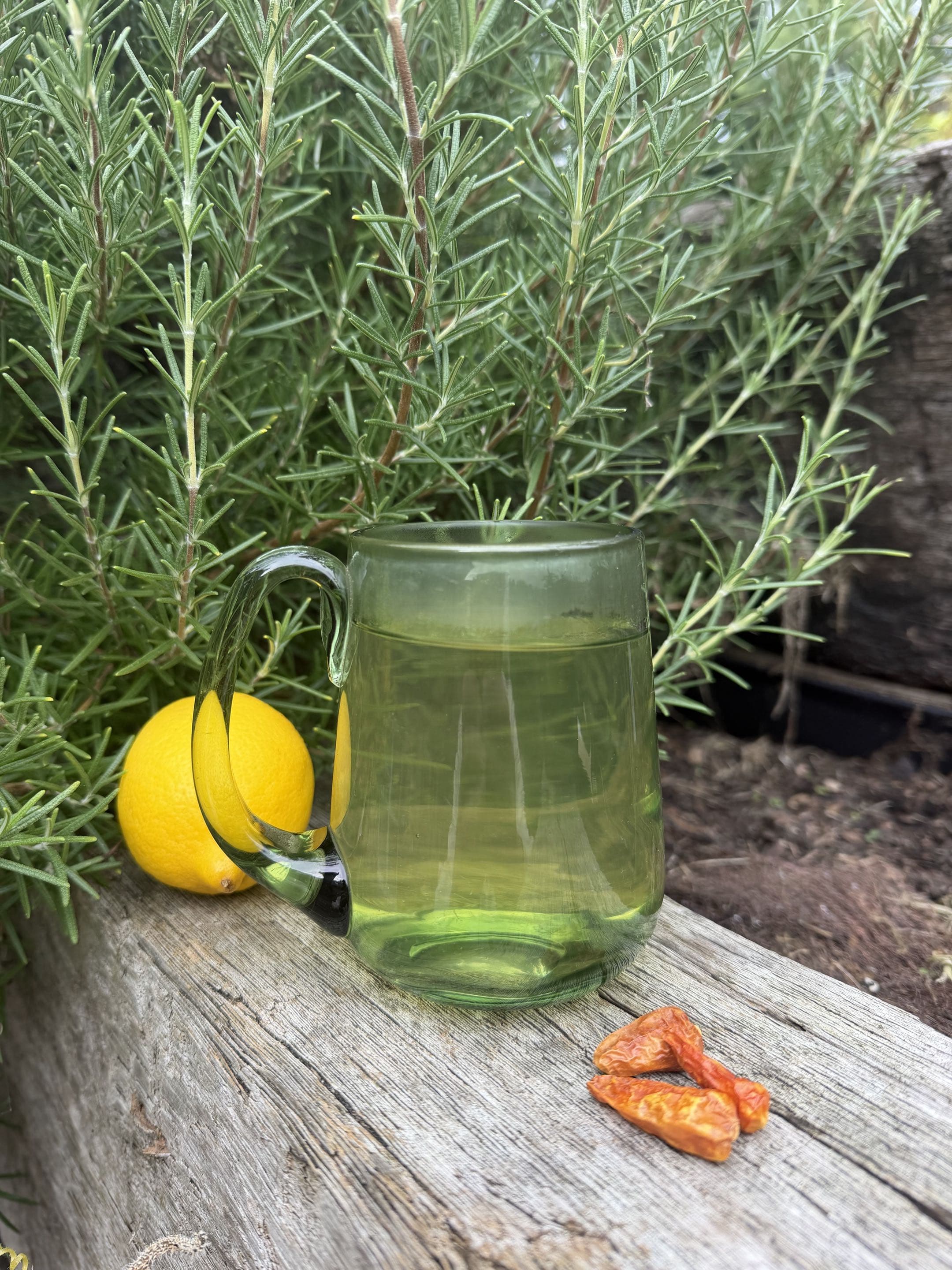 Schniffells served hot in a green glass mug on weathered timber, lemon and cayenne beside it